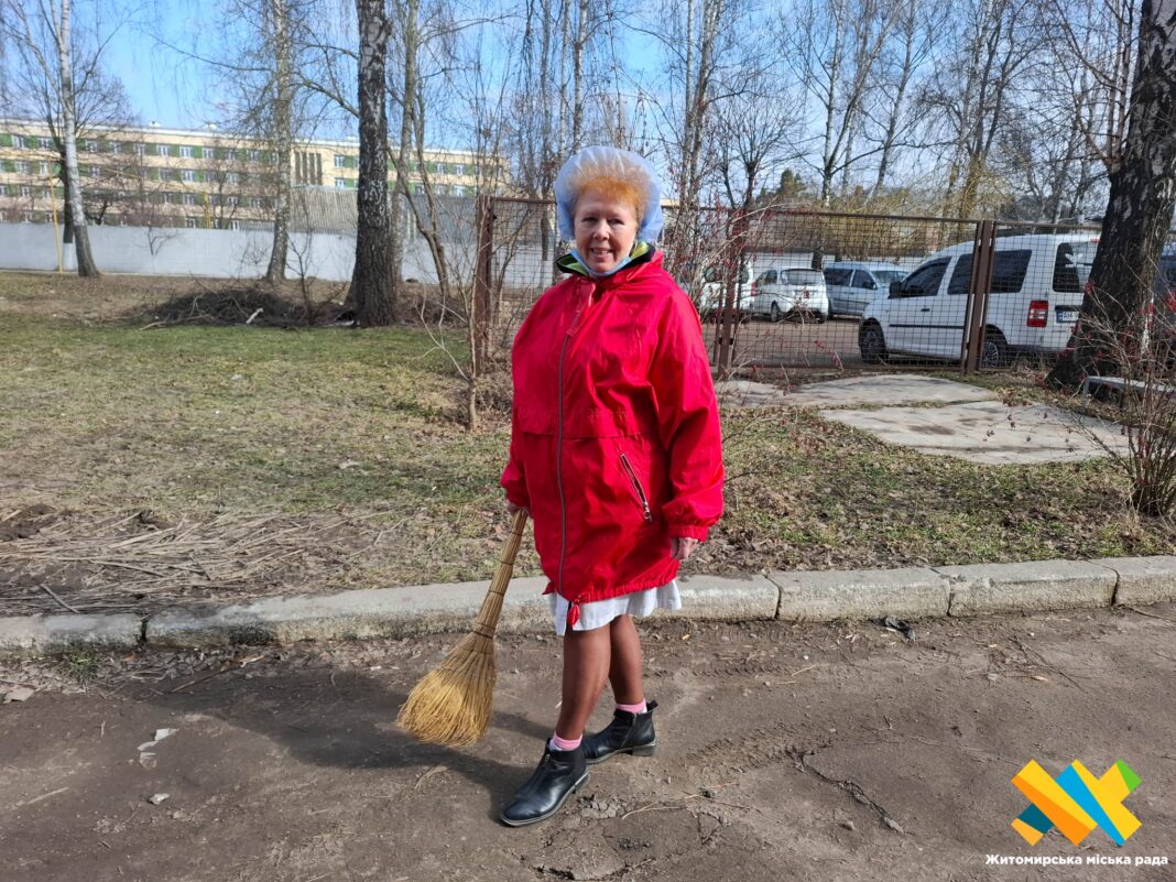 Працівниця житомирської лікарні з мітлою під час весняного прибирання території