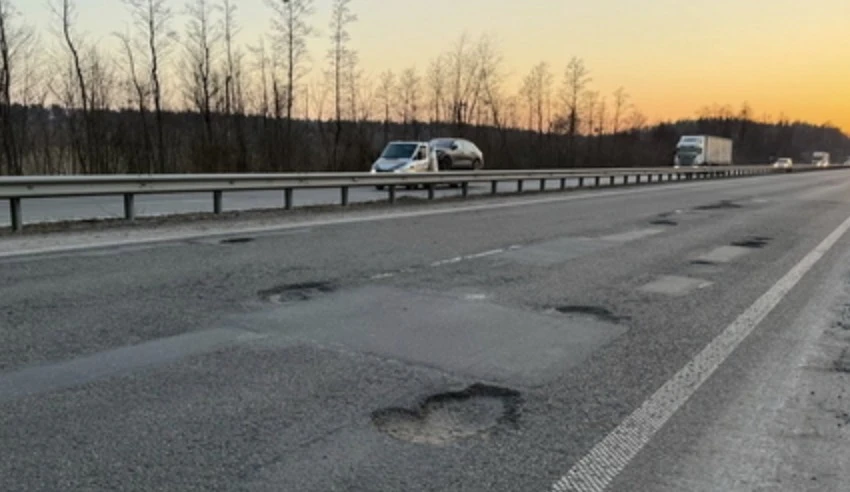 Стан доріг державного значення на Житомирщині Розбита траса з глибокими ямами на Житомирщині на фоні евакуатора