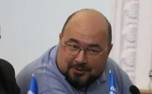 Депутат Житомирської міської ради Юрій Самборський у блакитній сорочці сидить на засіданні