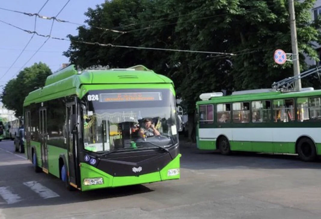 Зелений міський тролейбус рухається вулицею Житомира