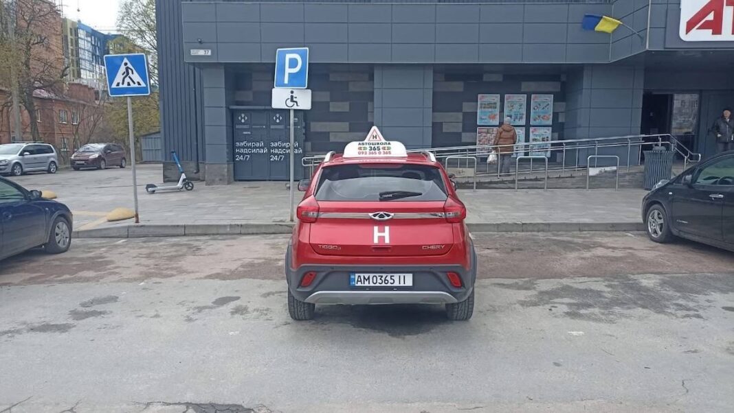Порушення правил паркування навчальним автомобілем у Житомирі Червоний навчальний автомобіль Chery з літерою «Н» припаркований прямо під знаком парковки для людей з інвалідністю біля супермаркету