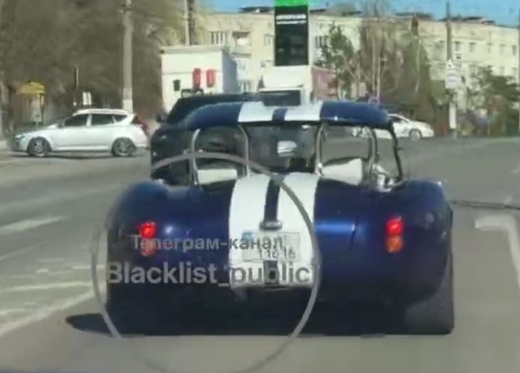 Легендарний відкритий синій спорткар Shelby Cobra з двома білими гоночними смугами їде дорогою у Житомирі