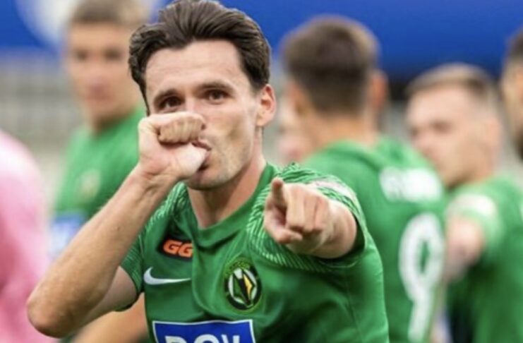 Гравець житомирського футбольного клубу «Полісся» у зеленій формі емоційно святкує гол, вказуючи пальцем у камеру